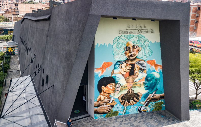 Artistas urbanos antioqueños pintan mural sobre reconciliación en la fachada del museo casa de la memoria